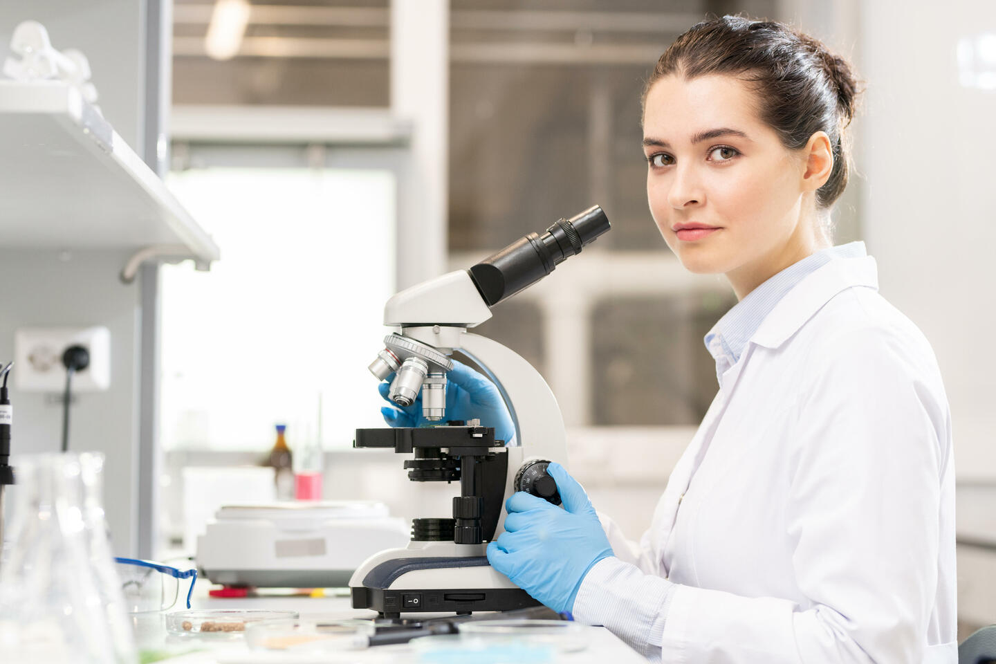 Femme chercheure dans son laboratoire avec microscope