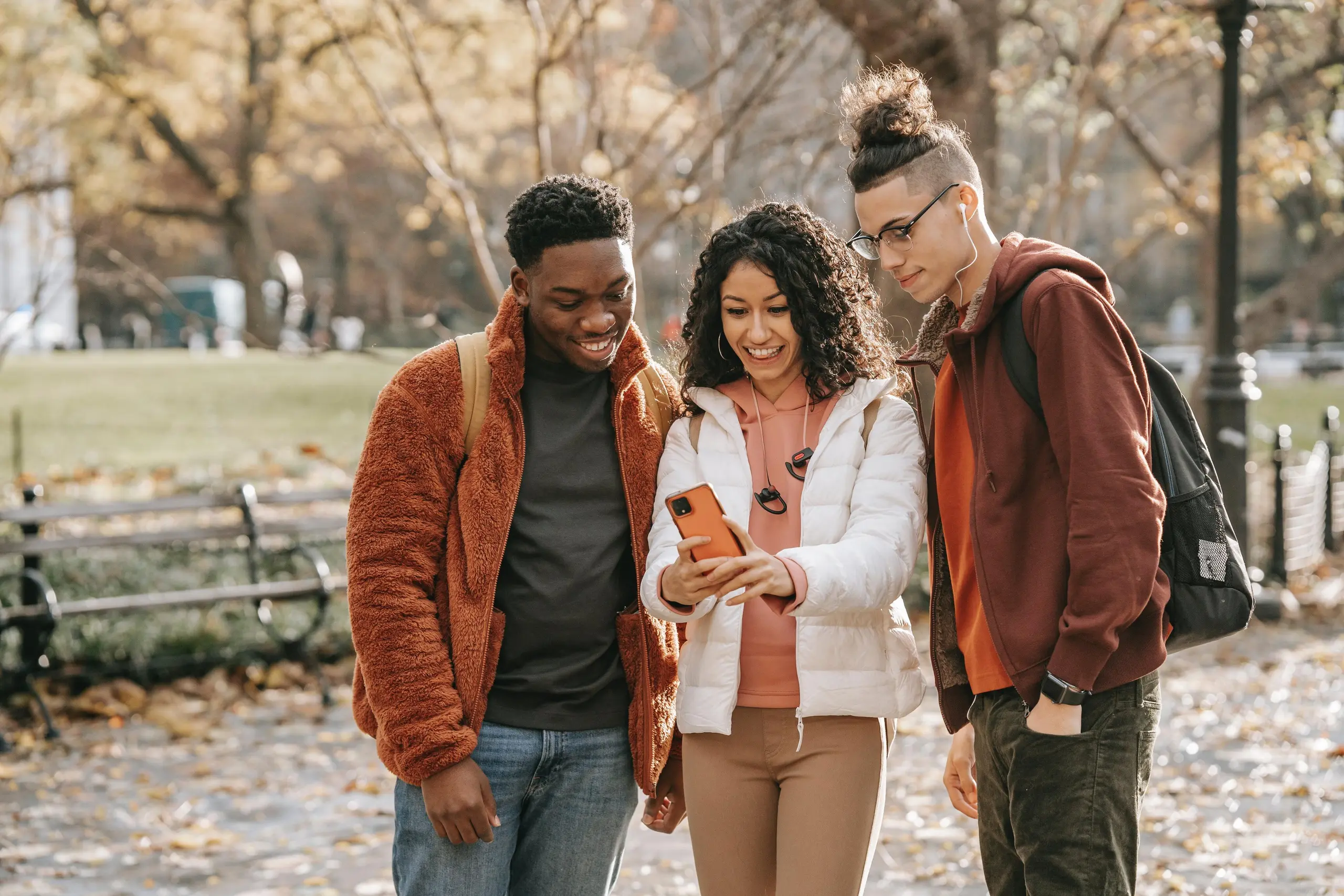 Trois adolescents regardent un téléphone