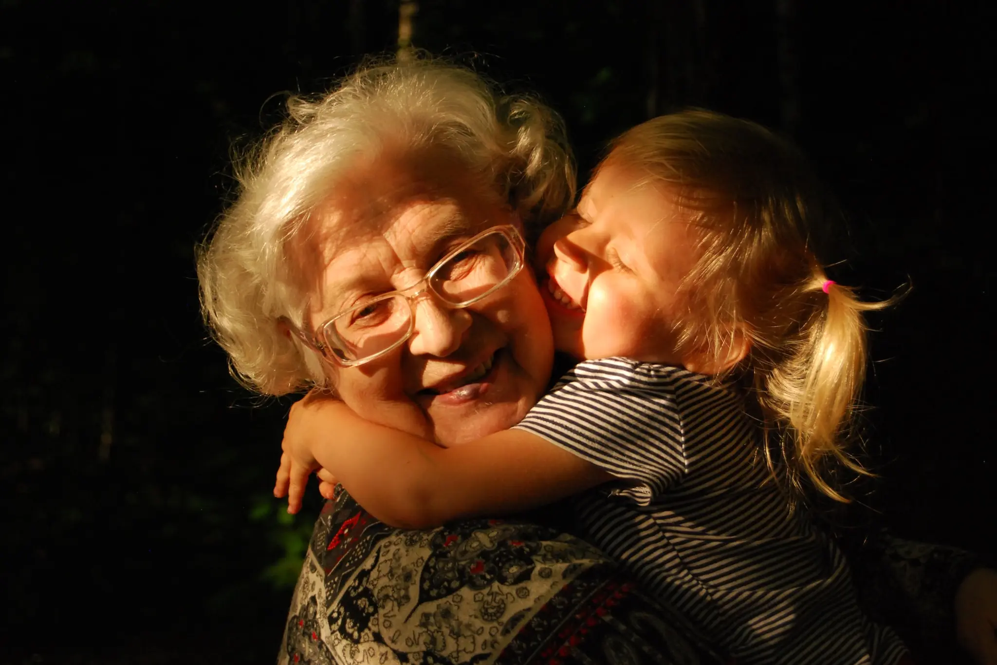 Une mamie et sa petite fille qui se font des câlin 